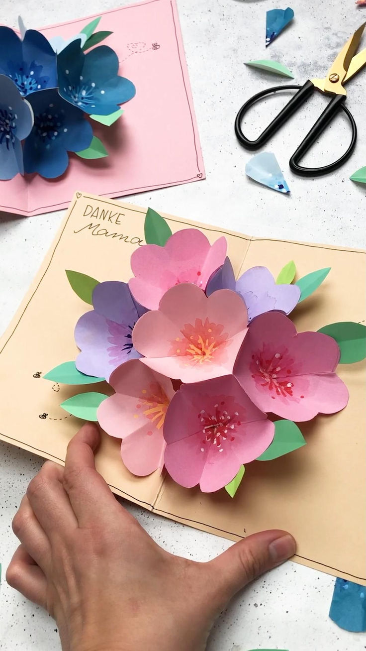 paper flowers are being made with scissors and other crafting supplies on a table top