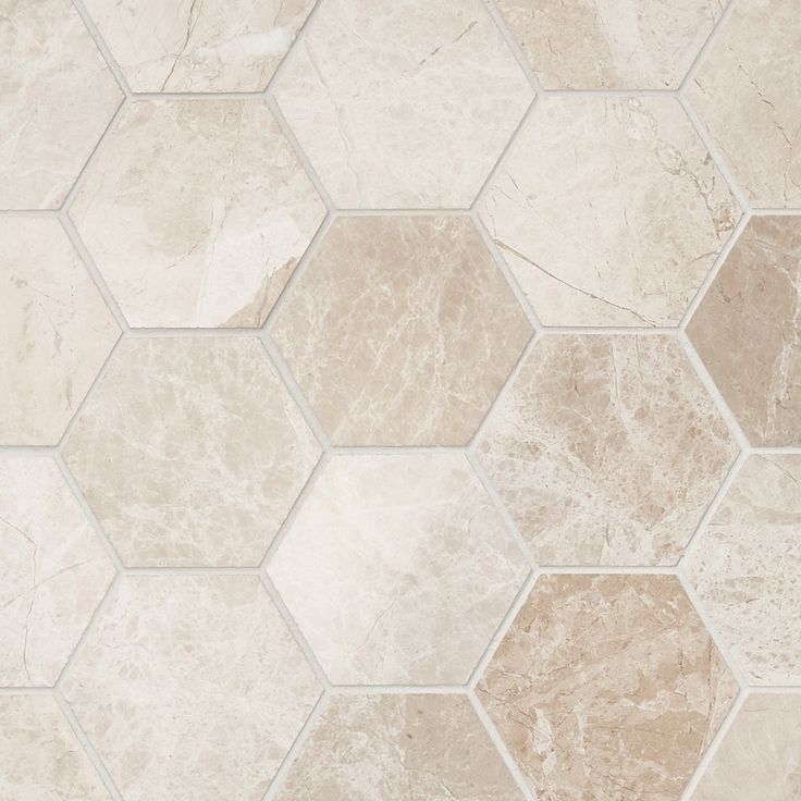 a white and beige tile floor with hexagonal tiles on the bottom one side