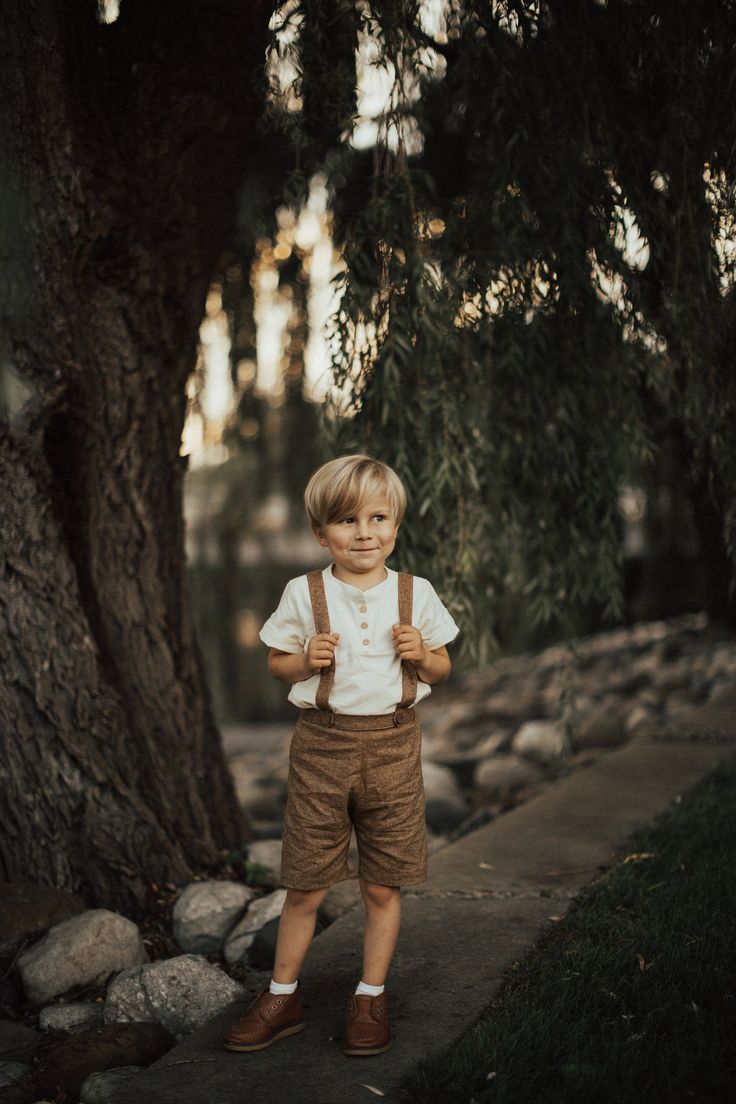 My current processing time is 3-4 weeks before shipping. Please do not order if you need your item(s) before then :)  **Photos by Elsie Smith of This Moment Photography** If you're looking for the perfect vintage style outfit for your little guy, look no further! These brown linen suspender shorts are perfect for weddings, baptisms, holidays, christenings, family photos, or dressed down for everyday wear.  They are made of a soft linen blend with a luxurious texture, and feature a flat front, for a classic tailored fit, and elastic in the back waistband. The suspender straps button on to the shorts in the front and back, and have two buttonholes in the back to be able to adjust for longer wear. A velvet ribbon strip where the suspenders cross keeps the straps from slipping off of the shoul Vintage Outfits Boys, Toddler Wedding Outfit Boy, Boys Wedding Outfit, Baby Boy Wedding Outfit, Boys Ring, Toddler Suspenders, Baby Boy Easter Outfit Infants, Wedding Outfit For Boys