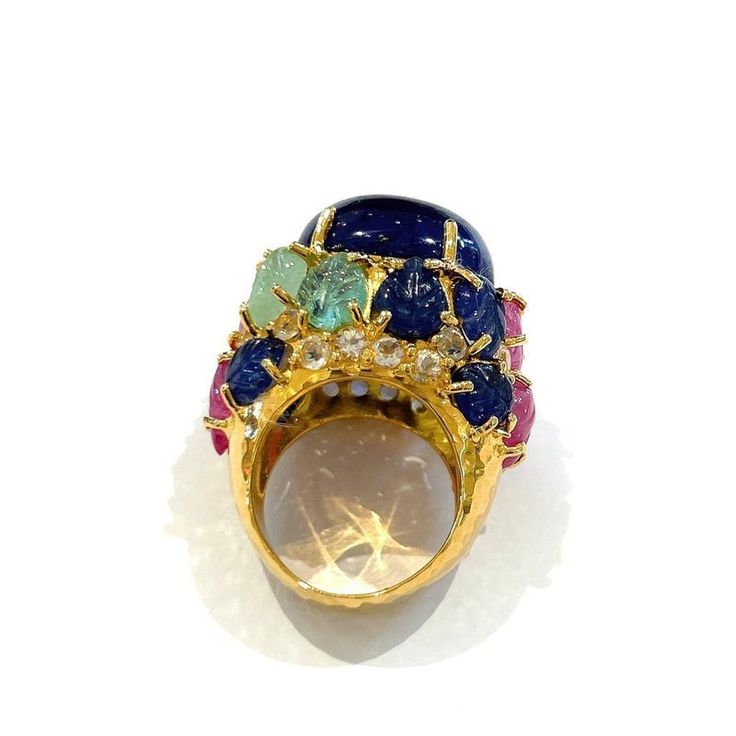 his is part of Chairish’s Fine Jewelry assortment.  Natural Blue Sapphire, Royal Blue Color, From Sri Lanka, Cabochon shape - 12 Carats   Carved floral Emeralds, Sapphires and Rubies - 6 Carats   White topaz - 1 Carat   This Ring is from the "Orient" traveling collection are the epitome of elegance and versatility. It offers a perfect blend of day to night and swimwear to evening wear, allowing you to effortlessly transition between different occasions and outfits. Wearing these spectacular orie Luxury Multi-stone Diamond Gemstones, Luxury Multi-stone Sapphire Gemstones, Multicolor Brilliant Cut Sapphire Ring For Formal Occasions, Luxury Multicolor Sapphire Ring, Luxury Multicolor Sapphire Ring For Formal Occasions, Multicolor Sapphire Ring For Formal Occasions, Formal Multicolor Round Sapphire Ring, Luxury Multicolor Cabochon Rings, Luxury Multicolor Sapphire Ring With Gemstone Accents