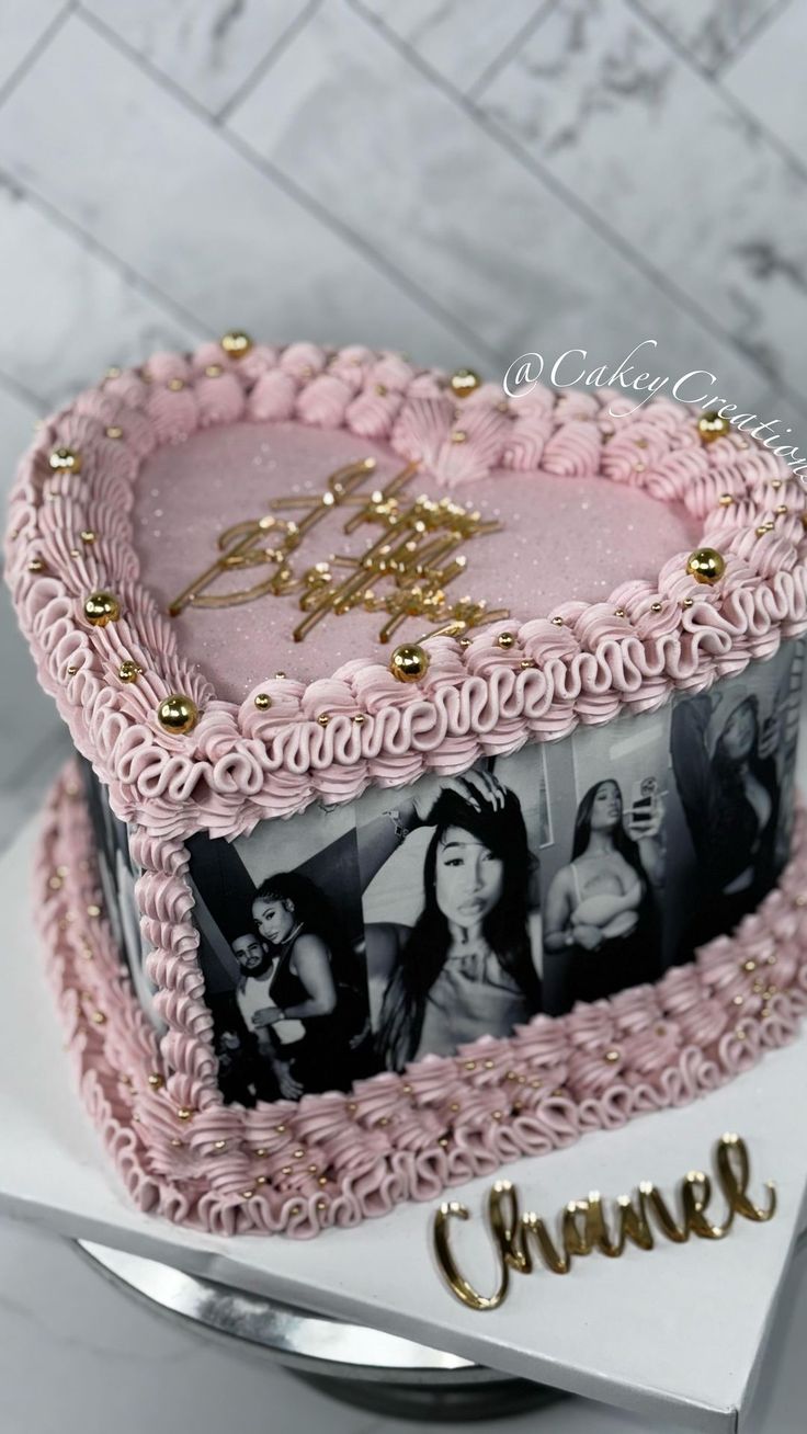 a pink cake decorated with photos and gold lettering