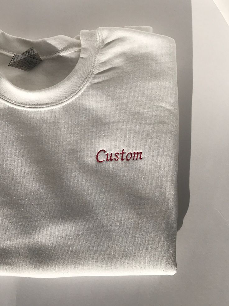 This listing is for a custom embroidered UNISEX crewneck sweatshirt. The more text you add the smaller the text will be. Interested in a different sweatshirt color, thread color, font, etc? Message us on Etsy to make a request. Please see the size chart in the product listing photos to determine the best size for you. Custom embroidered sweatshirts make a gift for any occasion - anniversary, bachelor party, bachelorette party, back to school, birthday, engagement, graduation, sweet 16's and quinceañera's, retirement, and weddings. They're also perfect for any holiday because this sweatshirt is customizable - Valentine's Day, St. Patrick's Day, Easter, Mother's Day, Father's Day, Halloween, Thanksgiving, Hanukkah, Christmas, and more. Or this could be a wonderful treat for yourself. These s White Cotton Sweatshirt With Custom Embroidery, Crew Neck T-shirt With Custom Embroidery, White Crew Neck Sweatshirt With Embroidered Logo, White Embroidered Logo Crew Neck Sweatshirt, White T-shirt With Letter Embroidery For Gift, White T-shirt With Letter Embroidery As Gift, White Long Sleeve T-shirt With Embroidered Logo, Customizable White Crew Sweatshirt, Basic Crew Neck Tops With Letter Embroidery