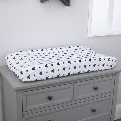 a gray dresser with a white and black blanket on top