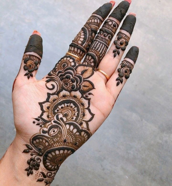 a woman's hand with henna tattoos on it