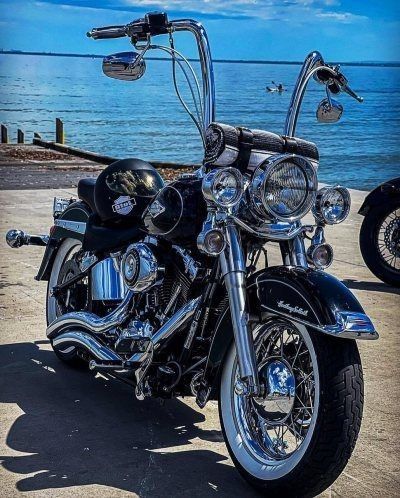 two motorcycles parked next to each other in front of the ocean and blue sky with clouds