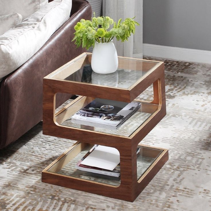 a living room with a couch, coffee table and two vases on the end tables