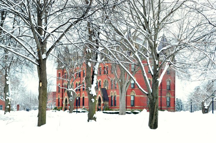 a large red building surrounded by trees covered in snow