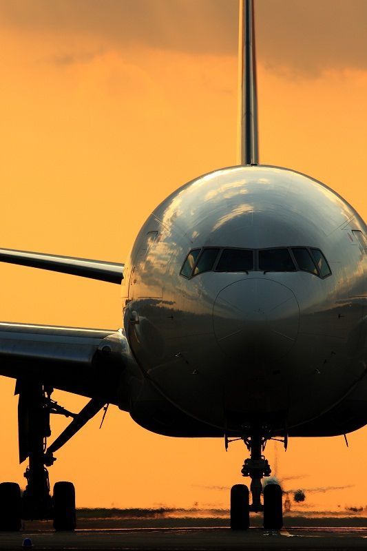 an airplane that is sitting on the runway at sunset or dawn, with it's landing gear down