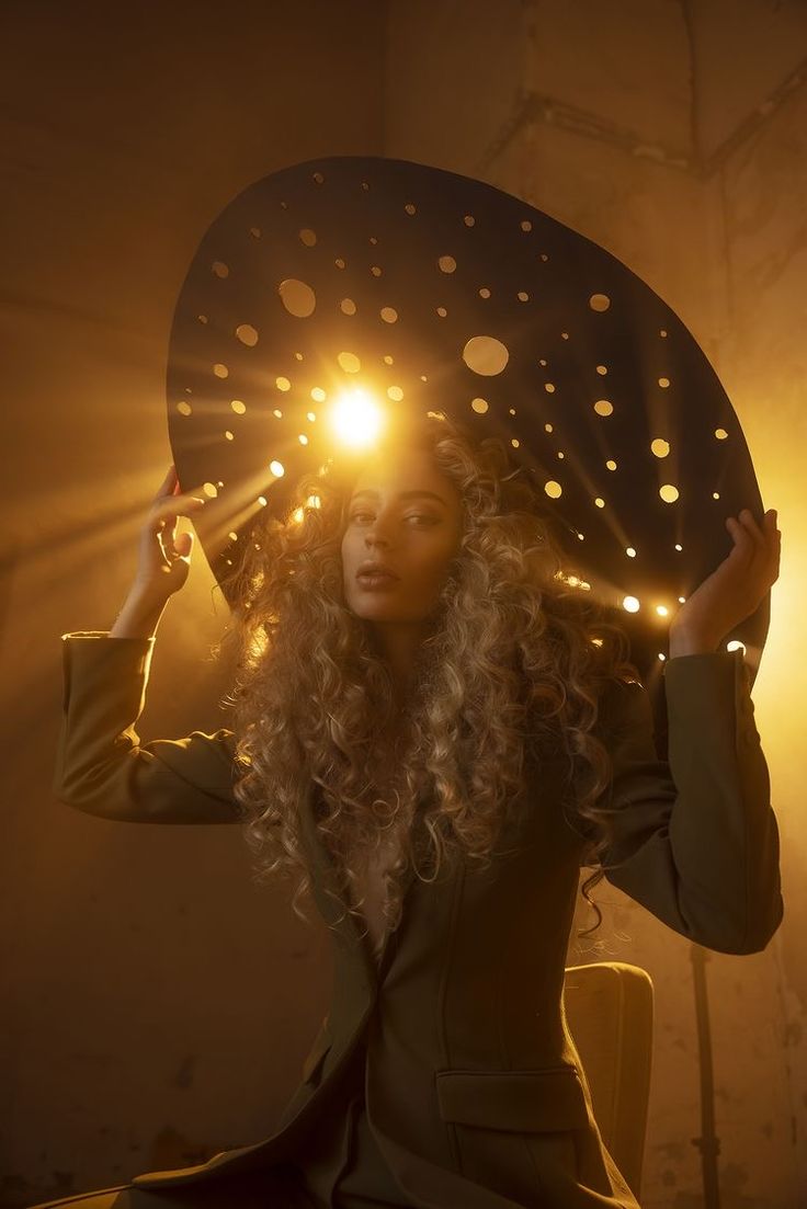 a woman holding an umbrella over her head with lights coming out of it's eyes