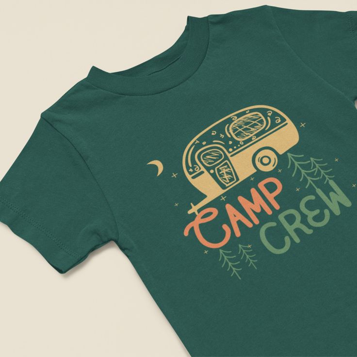 "Introducing our Kids' Camp Crew T-shirt, a delightful addition to your little one's outdoor wardrobe. This shirt showcases a charming camper and nature-inspired design with the words \"Camp Crew,\" perfect for young adventurers. Our T-shirt features a colorful illustration of a camper nestled among the trees and surrounded by the beauty of nature. The earthy tones and vibrant details capture the essence of outdoor exploration, making it the ideal choice for young nature enthusiasts. Searching for a thoughtful gift for a young adventurer? Our Camp Crew T-shirt is an excellent choice. It's perfect for birthdays, camping trips, or simply to inspire a love for the great outdoors." Cotton T-shirt With Funny Print For Outdoor Activities, Pre-shrunk Green T-shirt For Camping, Green Graphic Print T-shirt For Camping, Funny Print T-shirt For Outdoor Activities, Green Cotton Tops For Camping, Green Pre-shrunk T-shirt For Camping, Green T-shirt For Outdoor Activities, Green Crew Neck Top For Camping, Summer Green Top For Camping