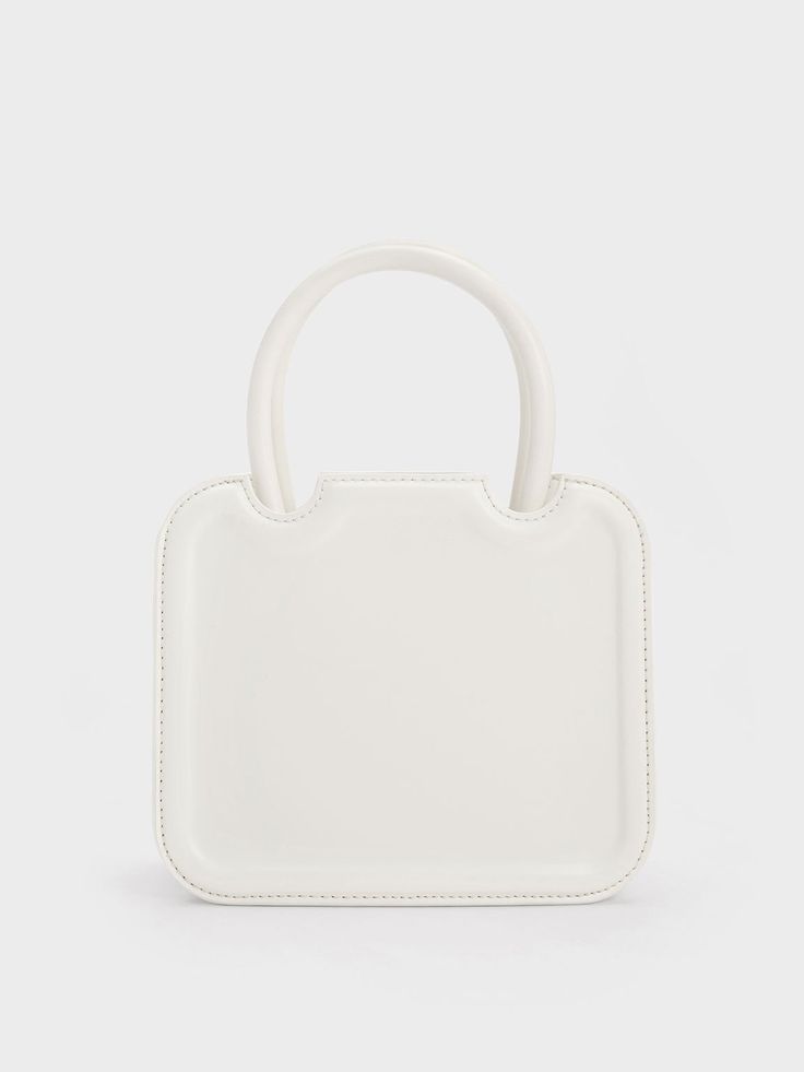 In classic white to match most outfits you can put together, the Perline sculptural tote bag is a worthy addition to your list of style staples. Featuring a square silhouette with rounded corners for a more feminine feel, the details make all the difference when it comes to this piece – the semicircle cut outs and gold-toned brand insignia add a touch of sophistication. Carry yours by the handles for a polished and sophisticated feel, or clip on the adjustable strap to create a cool and casual a Modern Rectangular Recyclable Bag, Trendy White Square Box Bag, Trendy White Box Bag For Daily Use, Casual White Box Bag With Removable Pouch, Eco-friendly White Bags For Everyday, Casual White Box Shoulder Bag, White Tote Shoulder Bag With Adjustable Handle, White Box Bag For Spring Shopping, White Box Bag For Shopping In Spring