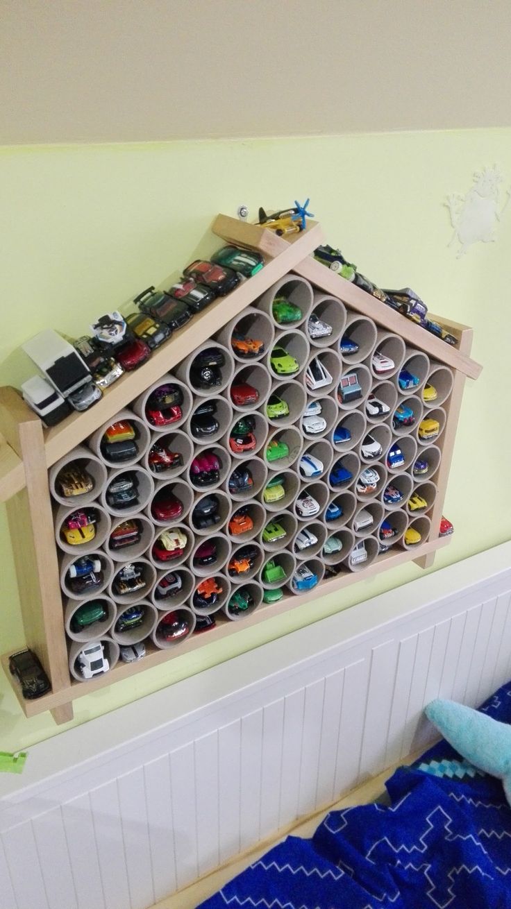 a child's bedroom with toys and toy cars on the shelf above the bed