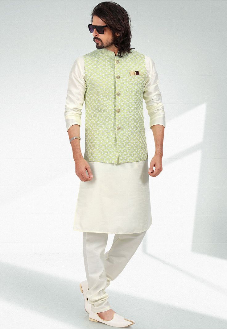 Art Silk Kurta in Cream  This Readymade attire is Enhanced with Buttons, Pockets and Resham Work. Crafted in Chinese Collar Neck and Full Sleeve Available with an Art Silk Churidar in Cream and an Art Silk Nehru Jacket in Pastel Green Do note: Footwear shown in the image is for presentation purposes only. Half to one inch may vary in measurement. (Slight variation in actual color vs. image is possible) Green Chanderi Nehru Jacket For Transitional Season, Transitional Green Chanderi Nehru Jacket, White Cotton Nehru Jacket With Cutdana, Festive Embroidered Pista Green Nehru Jacket, Green Chanderi Bandhgala With Long Sleeves, White Long Sleeve Chanderi Bandhgala, Spring Cotton Bandhgala With Resham Embroidery, Green Embroidered Bandhgala For Spring, Embroidered Green Bandhgala For Spring