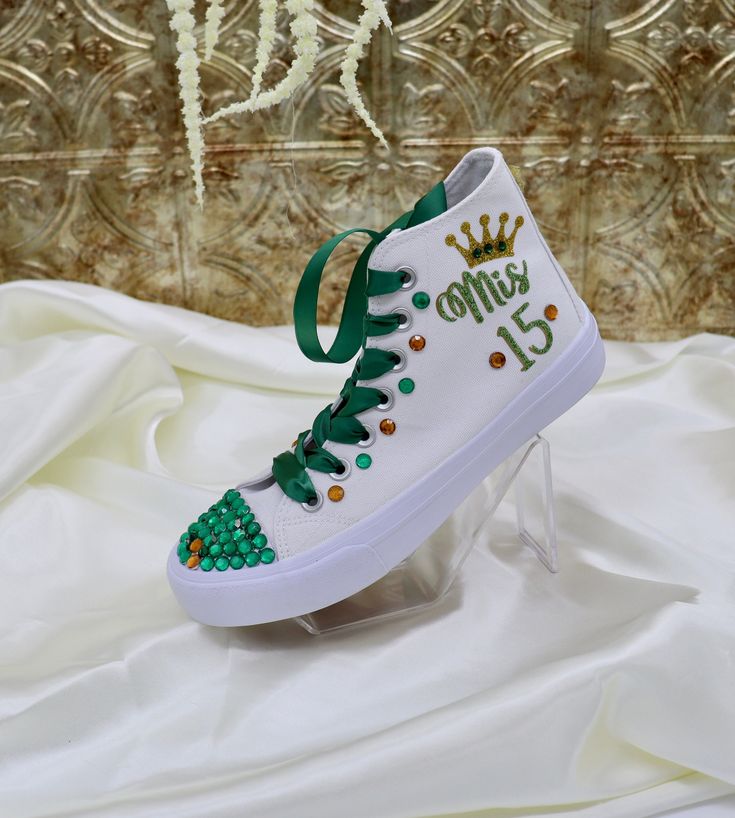 Quinceañera Hand-made Sneakers, for the celebration of a girl's 15th birthday, marking her passage from girlhood to womanhood. Make a statement with stunning decorated sneakers canvas, bedazzled with rhinestones, glitter, and other beautiful details. Make this spectacular gift as a real Queen Gift adding a tiara to your order :). See details below.  🌟Includes🌟 - Pick shoelace colors.  - The toe top is covered with bright rhinestones (mixing primary and secondary colors). - On the sides of the shoe (right & left), the idea/name/date is printed in solid or glitter color. - The back has a delicate small bow and the year printed. 🧡You will receive🧡 - One pair of sneaker canvas off-brand - One special custom bag for the shoes 🙏Working together🙏 - You can pick the combination of the colors Decorated Sneakers, Quince Shoes, Quince Party, Quinceanera Shoes, Personalized Sneakers, Queen Gifts, Secondary Colors, Primary And Secondary Colors, Real Queens