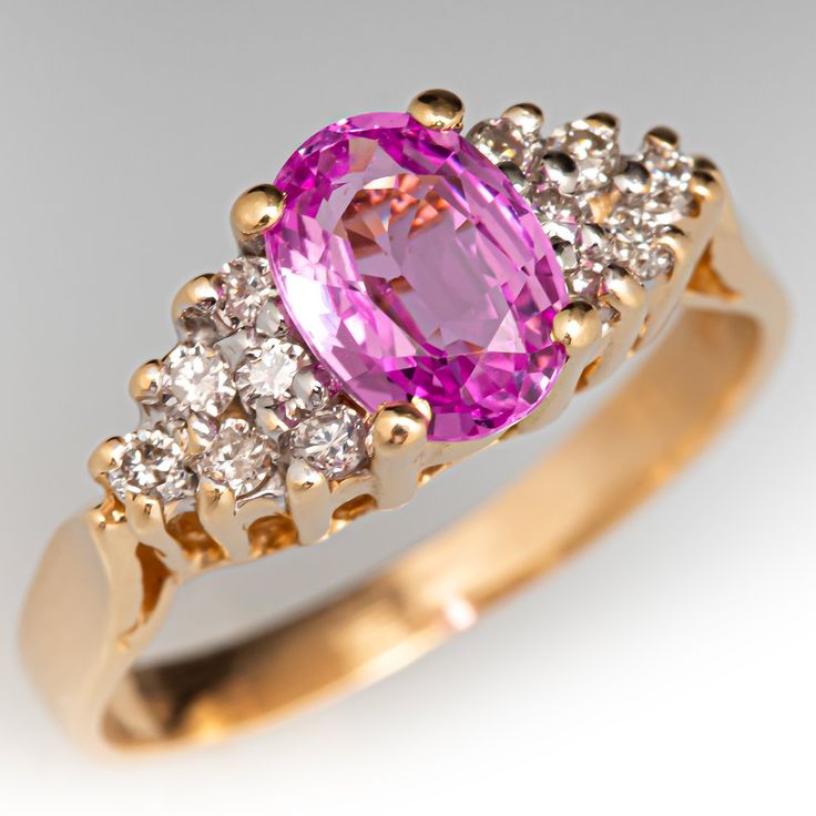 This sweet ring is centered with an oval cut pink sapphire, weighing 1.00 carat, in a four-prong setting. The shoulders are each bead set with six (6) round brilliant cut diamonds. The ring measures 6.9mm at the top, rises 6.3mm above the finger, tapering to 2.0mm wide and 0.7mm thick at the base of the shank. The ring currently fits a size 4.75. Luxury Pink Gold Sapphire Ring As Gift, Classic Pink Diamond Ring With Accents, Oval Pink Sapphire Diamond Ring With Accents, Classic Pink Diamond Ring With Center Stone, Classic Pink Sapphire Ring With Rose Cut Diamonds, Pink Oval Diamond Ring With Brilliant Cut, Heirloom Pink Sapphire Ring With Prong Setting, Oval Brilliant Cut Pink Sapphire Ring, Pink Sapphire Ring With Diamond Accents Round Cut