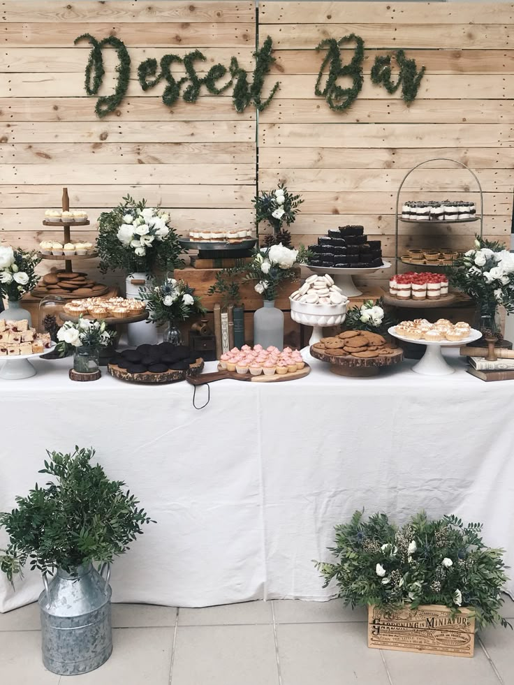 a table topped with lots of desserts next to a sign that says desert boy