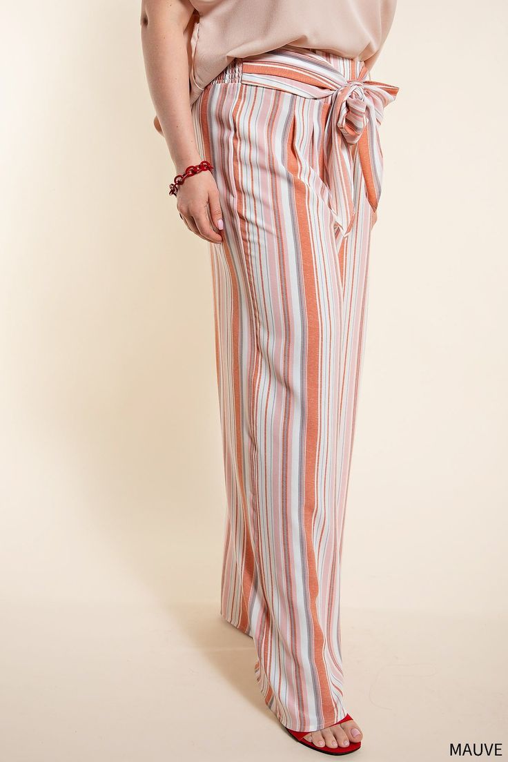 Workwear for the modern office — step up your 9 to 5 game with the One to Remember Tie Front Pants. These classic striped pants have been amped up with a smocked back and a tie front for a comfortable and stylish look. The mauve and white color combination makes them perfect for the Spring and Summer seasons, and the wide leg silhouette makes these long pants the perfect smart-casual choice. Get the perfect blend of comfort and style with the One to Remember Tie Front Pants. 100% Polyester Want Striped Wide Leg Pants With Elastic Waistband For Work, Striped Wide Leg Trousers With Elastic Waistband, Striped Wide-leg Pants With Elastic Waistband, Chic Striped Pants With Elastic Waistband, Spring Pinstripe Bottoms With Elastic Waistband, Striped Wide Leg Ankle-length Pants With Elastic Waistband, Striped Trousers With Elastic Waistband, Striped Straight Pants With Elastic Waistband, Straight Striped Pants With Elastic Waistband