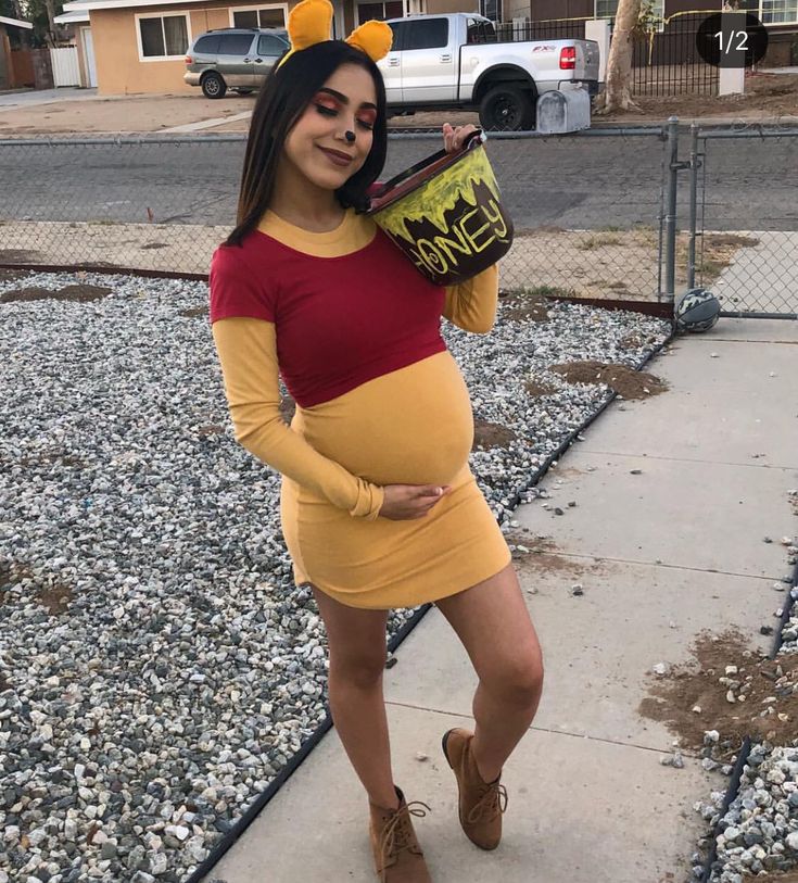 a pregnant woman dressed as winnie the pooh is posing for a photo in her costume