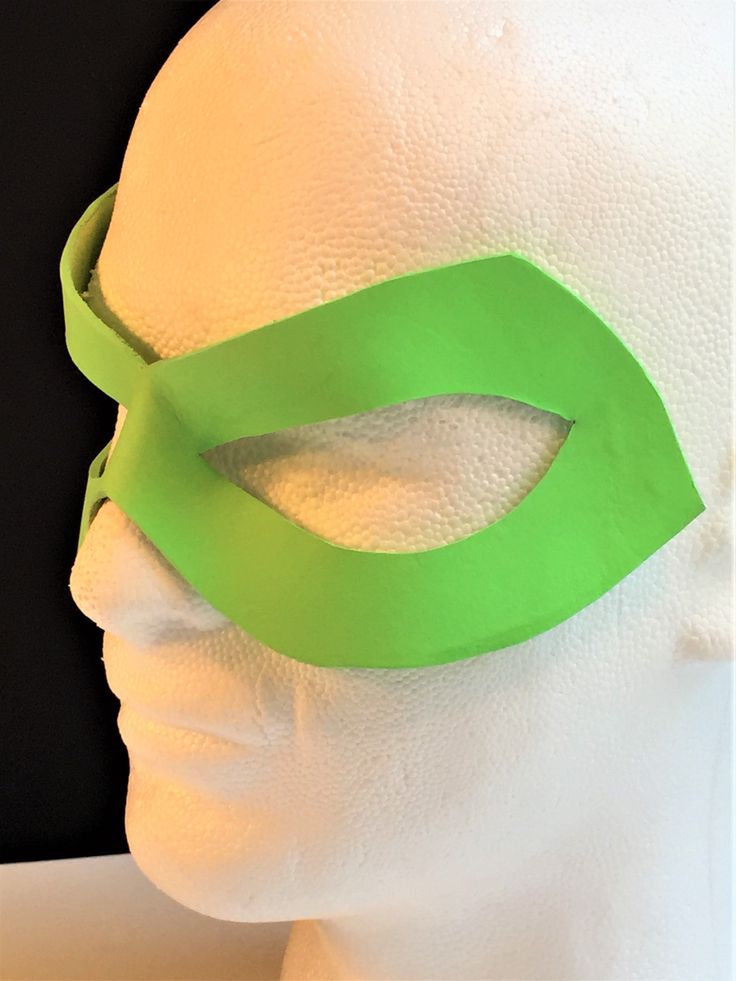 a white mannequin head wearing a green mask