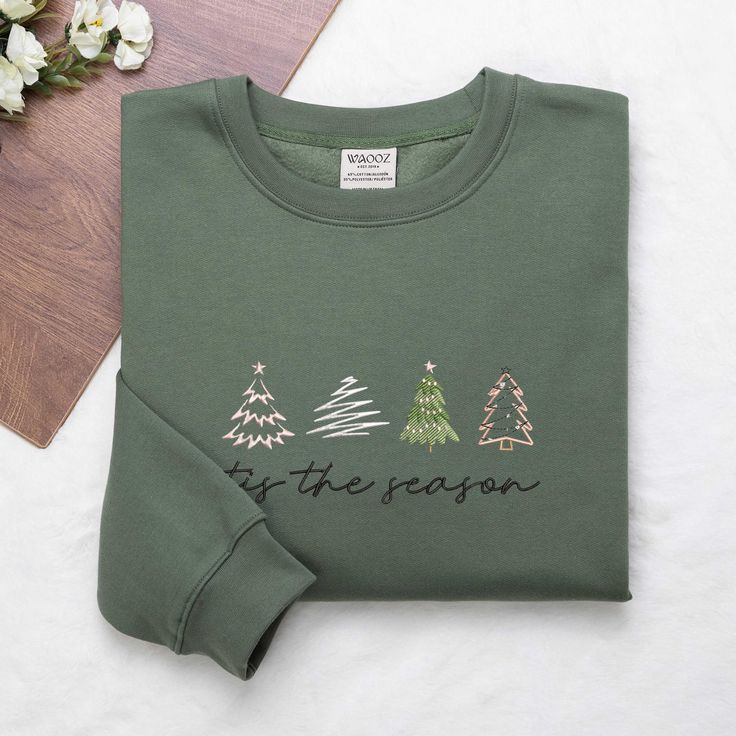 Christmas Trees Embroidered Sweatshirt, Christmas Sweatshirt, Embroidered Christmas Sweatshirt, Tis The Season Sweatshirt ✨ PRODUCT INFORMATION: 🧵 Material: 65% cotton, 35% polyester 📏 Size and Color Charts: Refer to the photos 🔍 Features: Double-needle stitching on collar, shoulders, armholes, cuffs, and hem ❤️️ CARE INSTRUCTIONS: To keep your sweatshirt looking its best, please follow these care guidelines: 🧼 Machine wash cold, inside-out, on a gentle cycle 🌬️ Tumble dry on low heat or ha Embroidered Cotton Christmas Sweatshirt, Casual Christmas Tops With Embroidered Graphics, Holiday Embroidered Casual Sweatshirt, Casual Embroidered Christmas Top, Casual Embroidered Holiday Sweatshirt, Casual Holiday Embroidered Sweatshirt, Casual Embroidered Sweatshirt For Holiday, Christmas Cotton Sweatshirt With Embroidered Logo, Casual Christmas Sweatshirt With Custom Embroidery