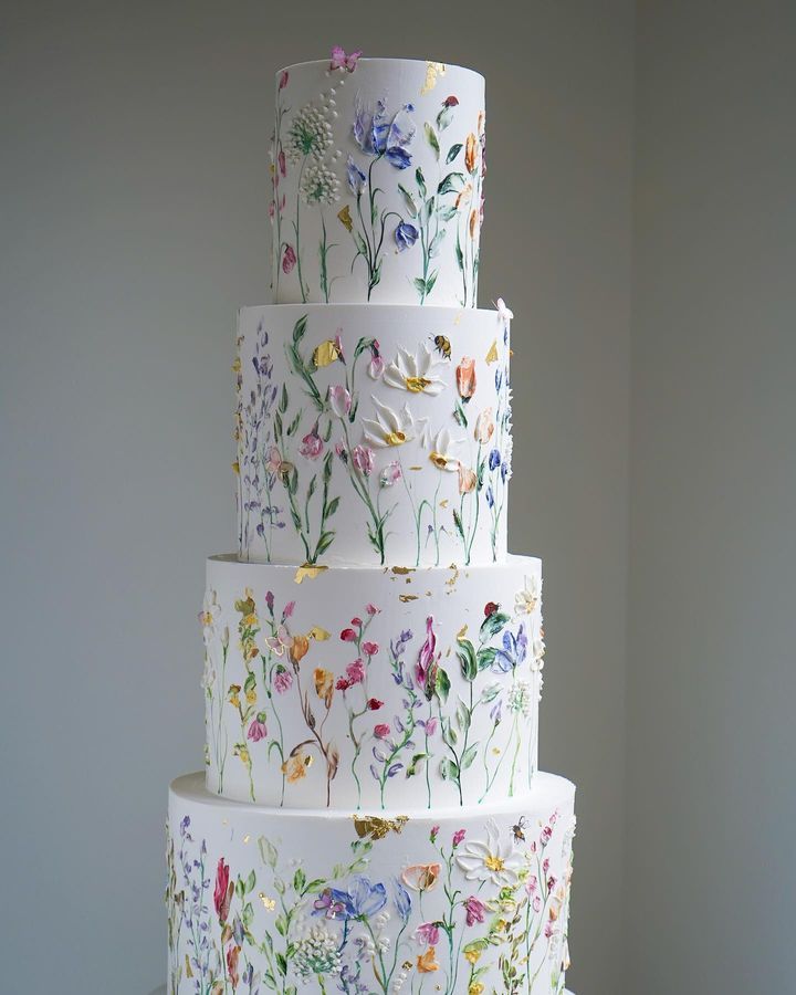 a multi - tiered cake decorated with colorful flowers