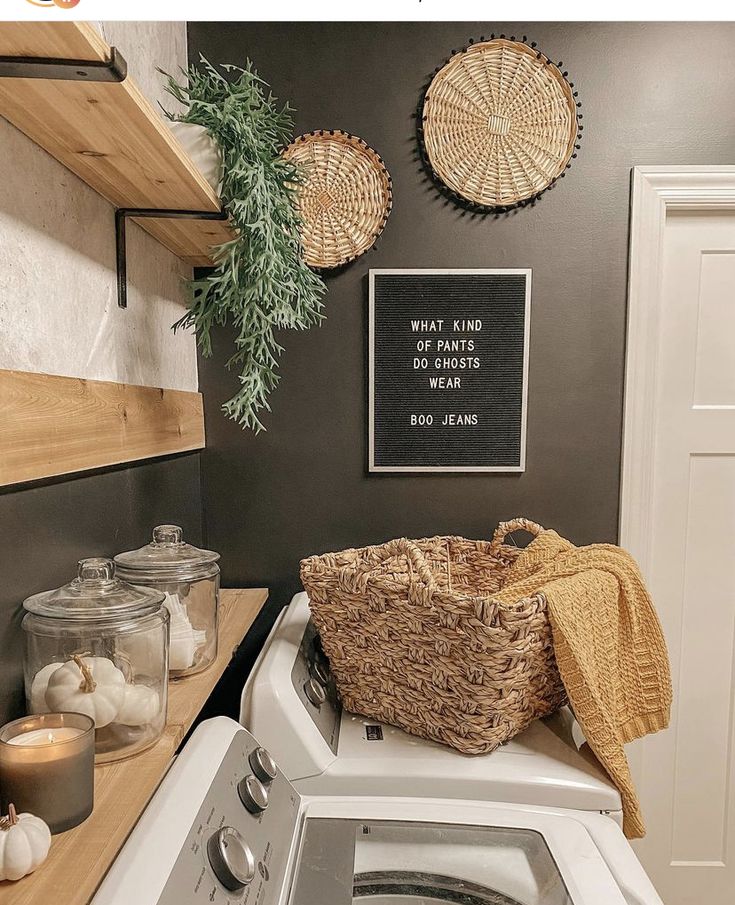 a washer and dryer in a small room with baskets on the wall above it