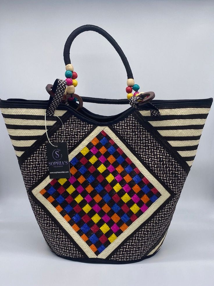 These beautiful handbags are made from Cana Flecha which is an indigenous palm fiber found in the northern territory of Colombia. They are beautifully hand crafted by the people from the Zenu tribes in Colombia. These handbags are colorful with vibrant colors, which is a pure reflection on the region and the warmness of these master artisans that work in this industry every day. Multicolor Woven Rectangular Bucket Bag, Handwoven Multicolor Square Bag, Multicolor Square Handwoven Bag, Multicolor Handwoven Square Bag, Artisan Multicolor Bucket Straw Bag, Artisan Multicolor Straw Bucket Bag, Traditional Multicolor Bucket Straw Bag, Palm Leaf Bucket Bag For Market, Artisan Multicolor Handwoven Shoulder Bag