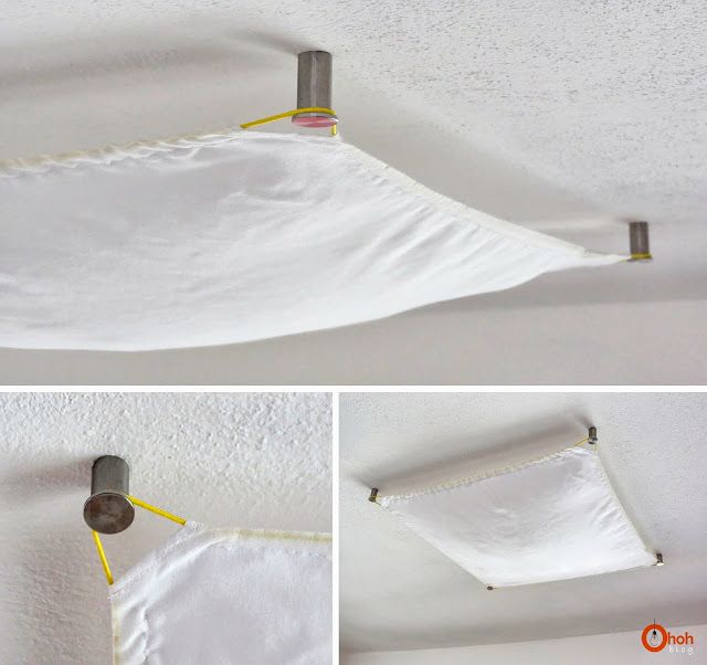 the ceiling is covered in white fabric and has two hooks on it to hold something