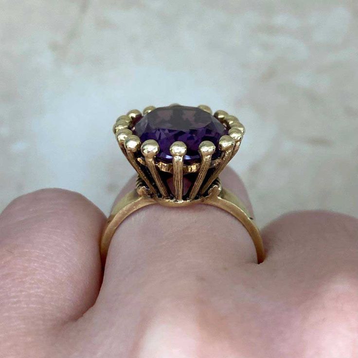 A bold vintage ring featuring an oval-cut amethyst center stone that weighs approximately 7 carats. This ring is mounted in 14k yellow gold. The center is surrounded by a halo of gold bead-shaped prongs. This ring was made in the 1970’s.
The measurements of this ring are approximately 17.82mm x 15.27mm.
The current size of this ring is 4.75 and can be resized at no extra cost.
Ready to Make It Yours? Contact us to reserve this ring and to get more info! Timeless Oval Gold Amethyst Ring, Timeless Yellow Gold Amethyst Ring, Timeless Gold Oval Amethyst Ring, Timeless Yellow Gold Amethyst Ring With Oval Shape, Classic Oval Amethyst Ring With Prong Setting, Classic Gold Amethyst Ring, Classic Yellow Gold Amethyst Ring, Classic Oval Amethyst Ring Collectible, Classic Yellow Gold Amethyst Ring With Prong Setting