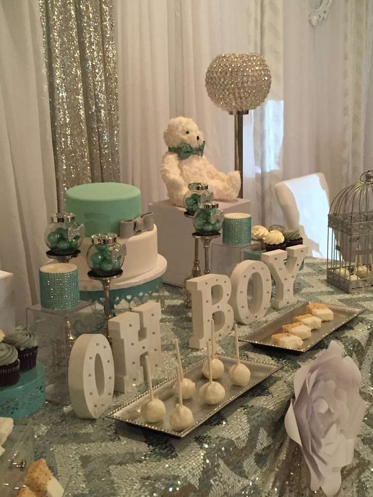 a table topped with lots of cakes and cupcakes next to a teddy bear