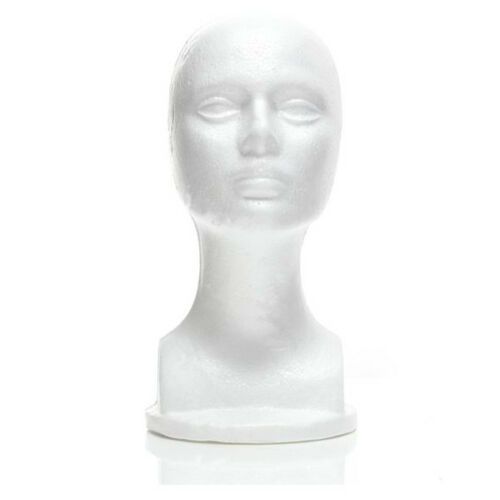 a white mannequin head with eyes closed on a white surface, viewed from the front