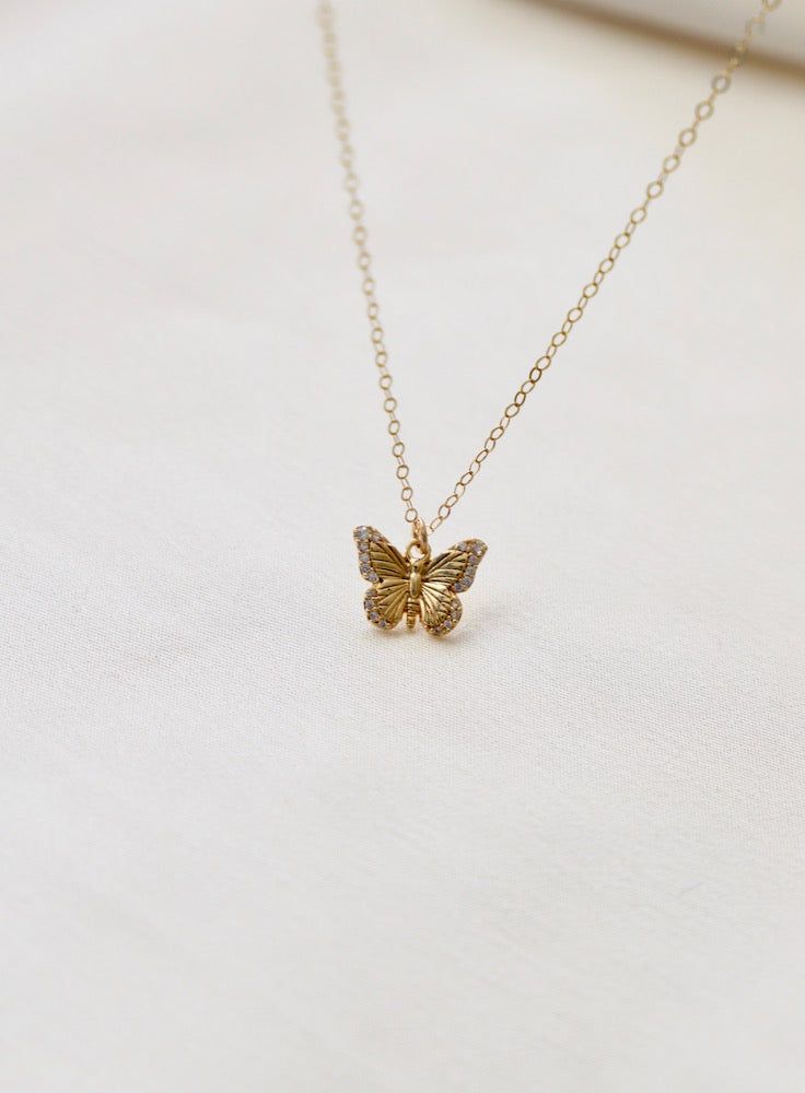 Delicate and sweet, this cubic zirconia butterfly necklace is a larger version to our Miniature CZ Butterfly Necklace . Butterflies symbolize transformation and hope which will make this a beautiful addition to your collection Materials: gold plate with cubic zirconia details Length: 18" gold chain SKU: CN1467G Materials+Care Luxury Yellow Gold Butterfly Necklace Dainty, Small Butterfly Necklace, Delicate Jewelry With Cubic Zirconia Butterfly Charm, Elegant Gold Butterfly Charm Necklace, Dainty Yellow Gold Butterfly Pendant Necklace, Yellow Gold Butterfly Shaped Jewelry With Cubic Zirconia, Yellow Gold Butterfly Necklace With Adjustable Chain, Yellow Gold Plated Butterfly Necklace, Delicate Yellow Gold Necklace With Butterfly Charm