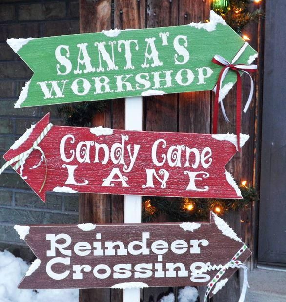 three wooden signs that say santa's workshop, candy cone lane and reindeer crossing