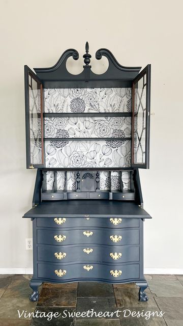 an old dresser has been painted blue and gold with white flowers on the top shelf