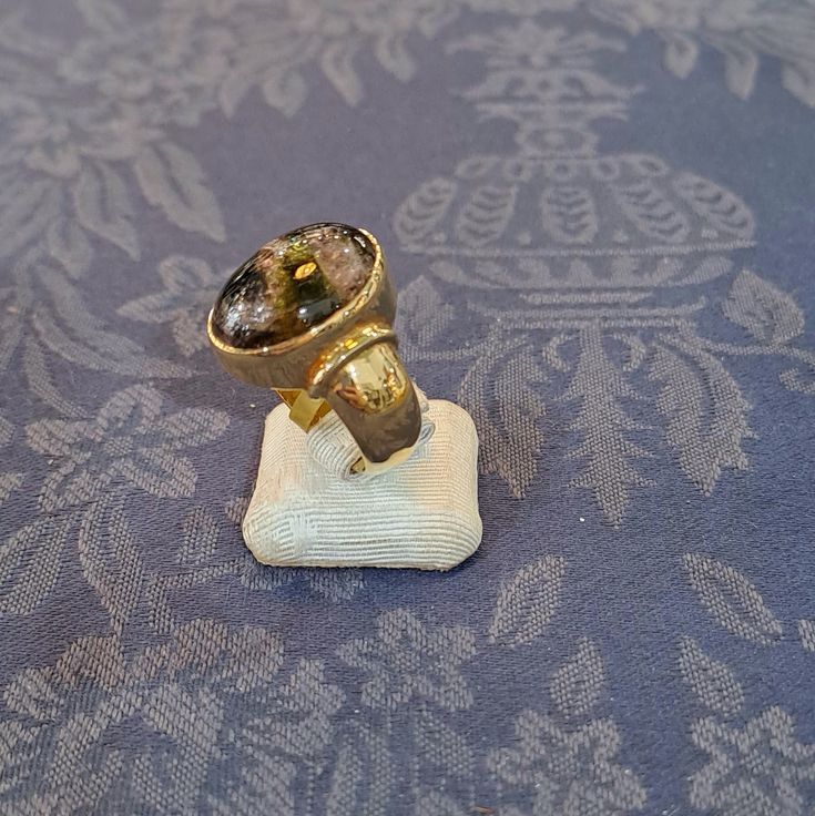 a gold ring sitting on top of a blue table cloth