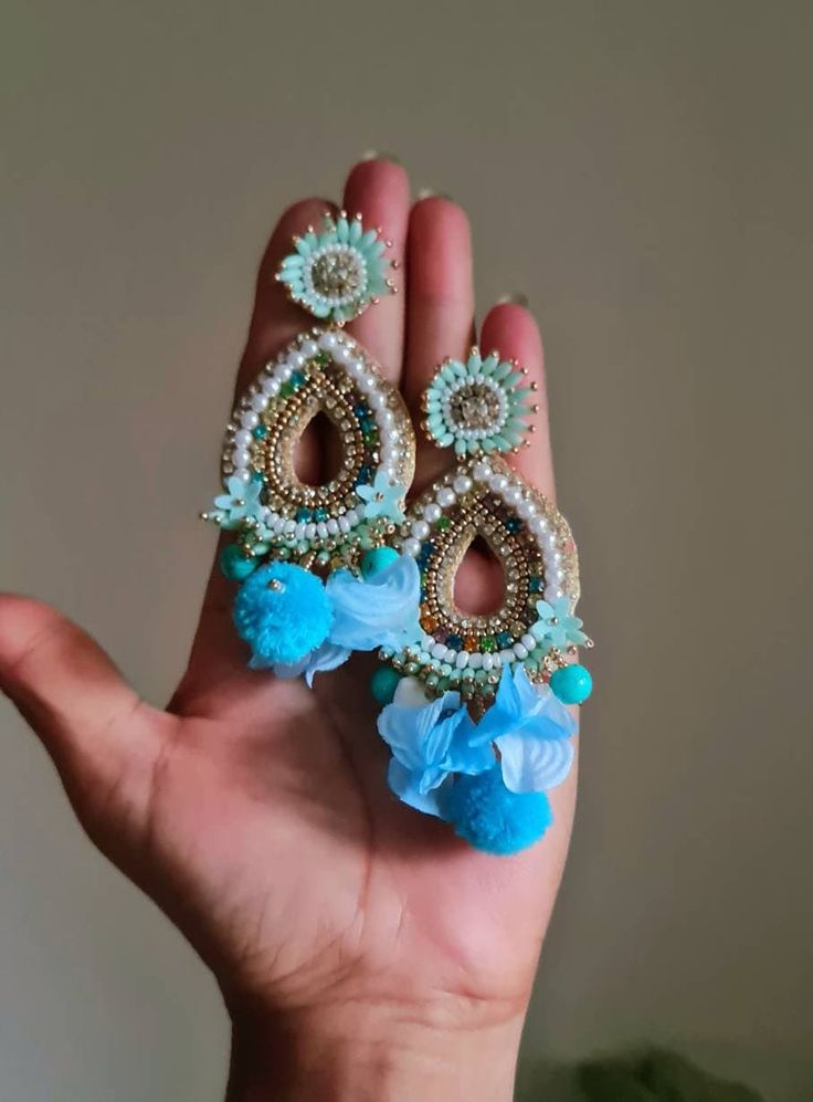 Bohemian handmade statement turquoise blue embellished large earrings. These beautiful turquoise earrings are hand crafted beautifully using various material like fabric, glass, chatton,pompoms etc. An ideal summer party earrings The earrings measure approx. 3.80" long and 2.20" wide. At Carnation jewellery, each piece is artisan handcrafted with love and care and shipped from India.  * SHIPPING - Please refer to the "announcement" page of the store. * Please be noted all kind of taxes, custom duties, VAT etc will be borne by the buyer as I am not responsible for the same. * For queries, please reach out to me and I shall revert ASAP. * PLEASE READ CAREFULLY THE SHOP ANNOUNCEMENT. Back to the store https://www.etsy.com/your/shops/ Carnation jewellery