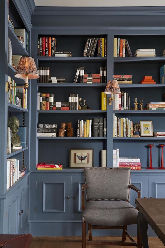 a chair sitting in front of a book shelf filled with books