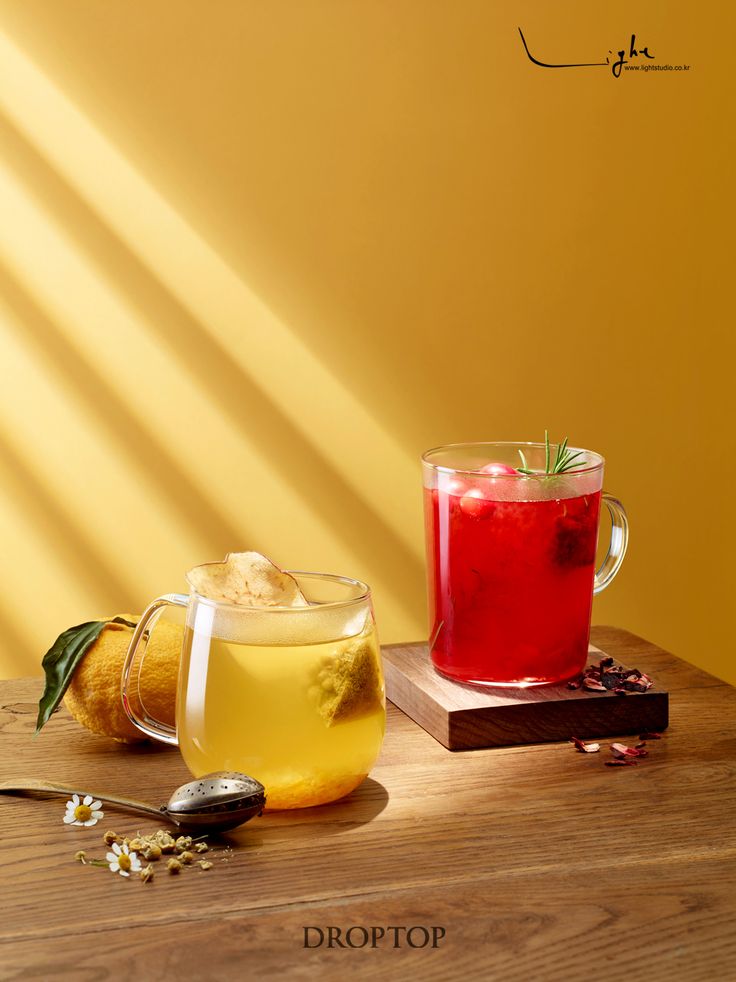 two glasses of tea sit on a table next to each other