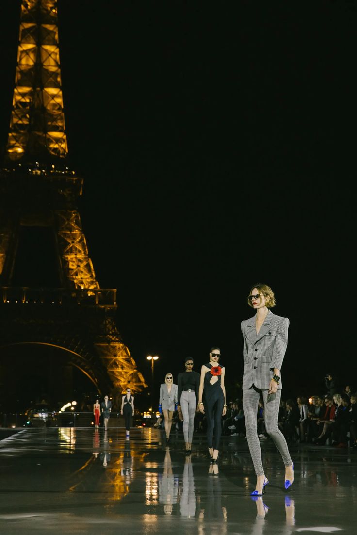 models walk down the runway in front of the eiffel tower