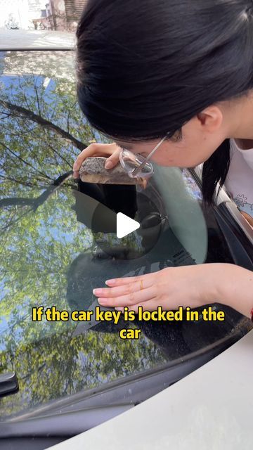 a woman is looking in the window of a car and touching her hand on the windscreen