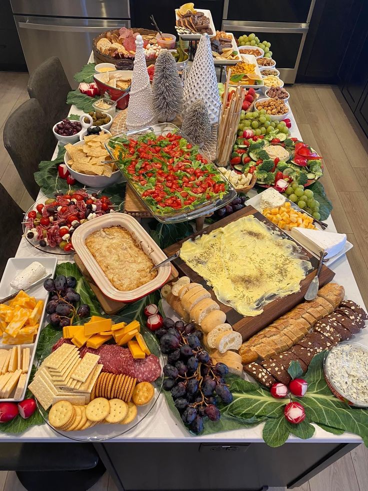 a table filled with lots of different foods and cheeses on top of it's sides