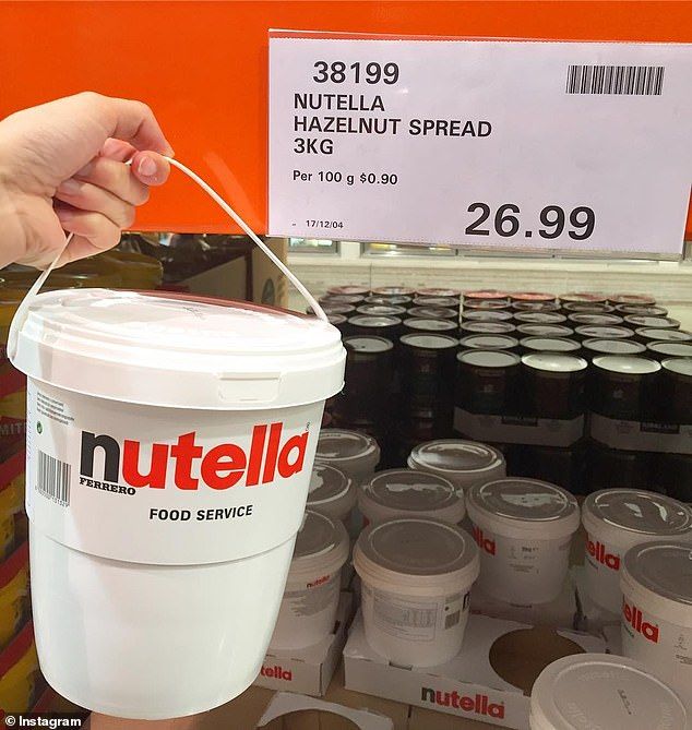 a hand is holding a bucket of nutella