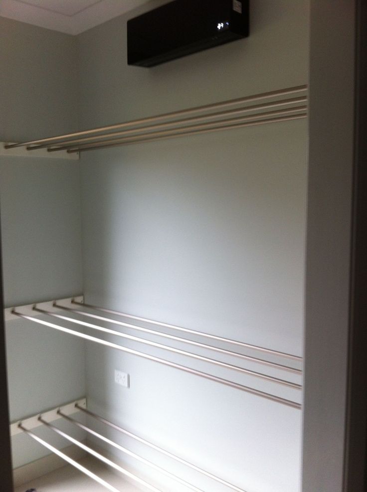 an empty closet with white shelves and no one in the room or there is a television mounted on the wall