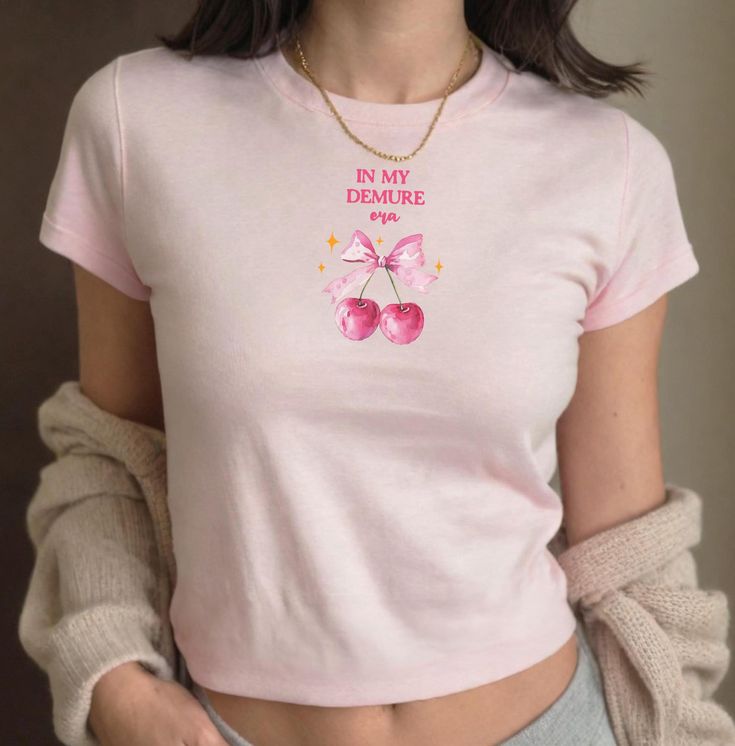 🎀 In My Demure Era baby tee fitted T shirt, Coquette Aesthetic girly baby tee, 90s Y2K crop tshirt, Women's top, pink and cherries crop top 🍒 Youth Size T-shirt, perfect "baby tee" fit (Gildan 5000B) ✨ 100% mid-weight US cotton 🤍  For a more tailored tee, order smaller size (S or XS) ❣️ Tear-away label 🍒 Available in white, black, sport grey, dark heather and Royal ✨Sizes available XS,S,M,L,XL MEASUREMENTS: X-small: body width:16 length:20.5 sleeve length: 13.5 Small: Body width:17 Length:22 Cute Crew Neck T-shirt, Kawaii Short Sleeve Tops With Letter Print, Kawaii Crew Neck Top With Letter Print, Spring Kawaii Letter Print Tops, Kawaii Summer Tops With Letter Print, Pink Funny Print Kawaii Tops, Kawaii Letter Print Tops For Summer, Pink Kawaii Top With Funny Print, Kawaii Letter Print Summer Tops