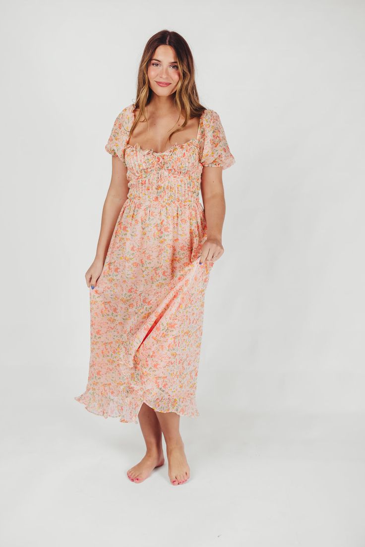 This stunning dress brings just the right amount of whimsy and charm to your wardrobe! The Lunaria Midi Dress offers a feminine, floral print that'll you'll love wearing to summer soirees, with a pleated, bustier-style bodice and underwire bra. You'll treasure this gem season after season. Available in two colorways. FIT: Runs true to size - very fitted in the bodice. Not recommended for D-cup and above. MATERIAL: 100% Polyester. Dry clean only. GARMENT DETAILS: Lightweight floral midi dress wit Floral Print Midi Dress With Fitted Bodice, Chic Summer Floral Dress With Fitted Bodice, Chic Floral Dress With Fitted Bodice For Summer, Peach Square Neck Summer Dress, Summer Chiffon Midi Dress With Fitted Bodice, Floral Print Dress With Fitted Bodice For Garden Party, Feminine Floral Dress With Smocked Bodice, Summer Floral Dress With Sweetheart Neckline For Brunch, Fitted Bodice Floral Dress For Garden Party