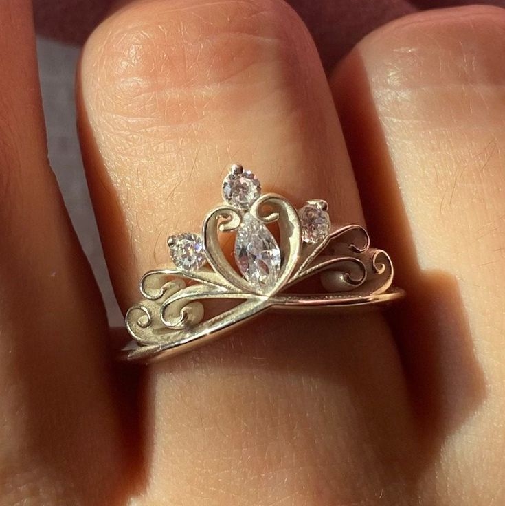 a close up of a person's hand with a gold ring on it and a diamond in the middle