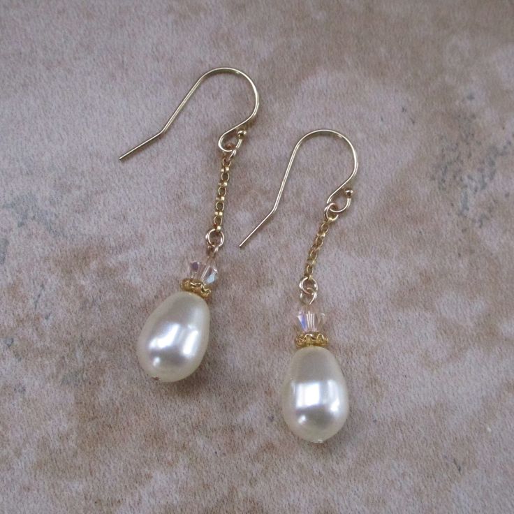 You will love the luster of teardrop Swarovski pearl earrings. These earrings add are simple yet elegant.  Swarovski crystal pearls imitate genuine pearls. Swarovski pearls have a crystal core and a lustrous coating that mimics pearls. *Swarovski teardrop pearls: .4 inch long by .3 inch wide *Accent beads: Swarovski crystals *14k gold-filled, ear wires and chain *Approximate earring length: 1.5 inches Gold Briolette Teardrop Earrings For Wedding, Elegant Briolette Teardrop Hypoallergenic Earrings, Elegant Hypoallergenic Briolette Teardrop Earrings, Elegant Briolette Teardrop Earrings Gift, Elegant Teardrop Briolette Earrings With Pearl Drop, Elegant Briolette Teardrop Earrings, Classic Pearl Teardrop Dangle Earrings, Classic Dangle Pearl Earrings For Mother Of The Bride, Teardrop Pearl Earrings For Mother Of The Bride