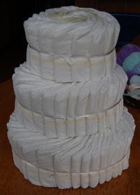 three stacks of toilet paper sitting on top of a wooden table next to yarn balls