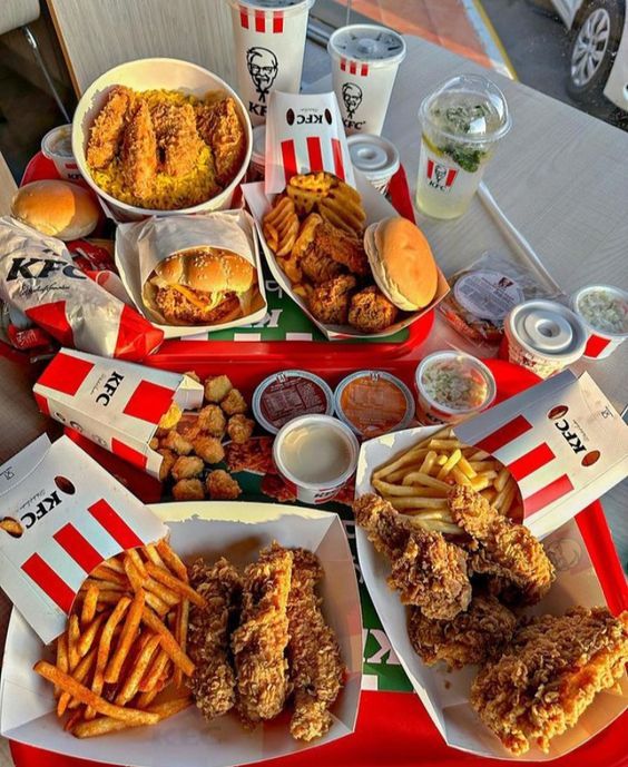 a table topped with plates of food and cups of drinks next to each other on top of a red tray