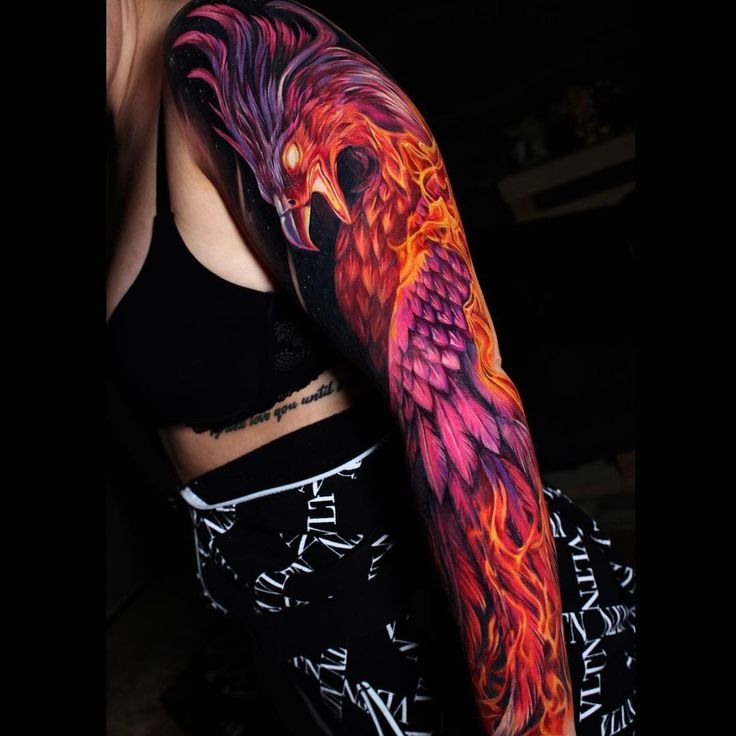 a woman's arm with an orange and pink bird on it